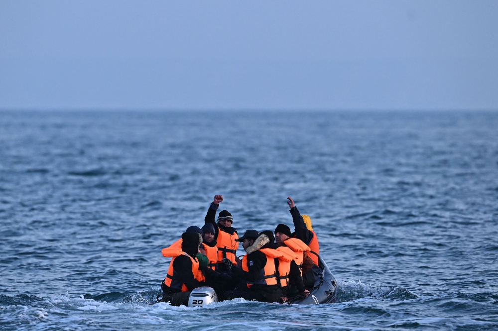 (Files) Migrants travel in an inflatable boat across the English Channel, bound for Dover on the south coast of England. (Photo by Ben Stansall / AFP)