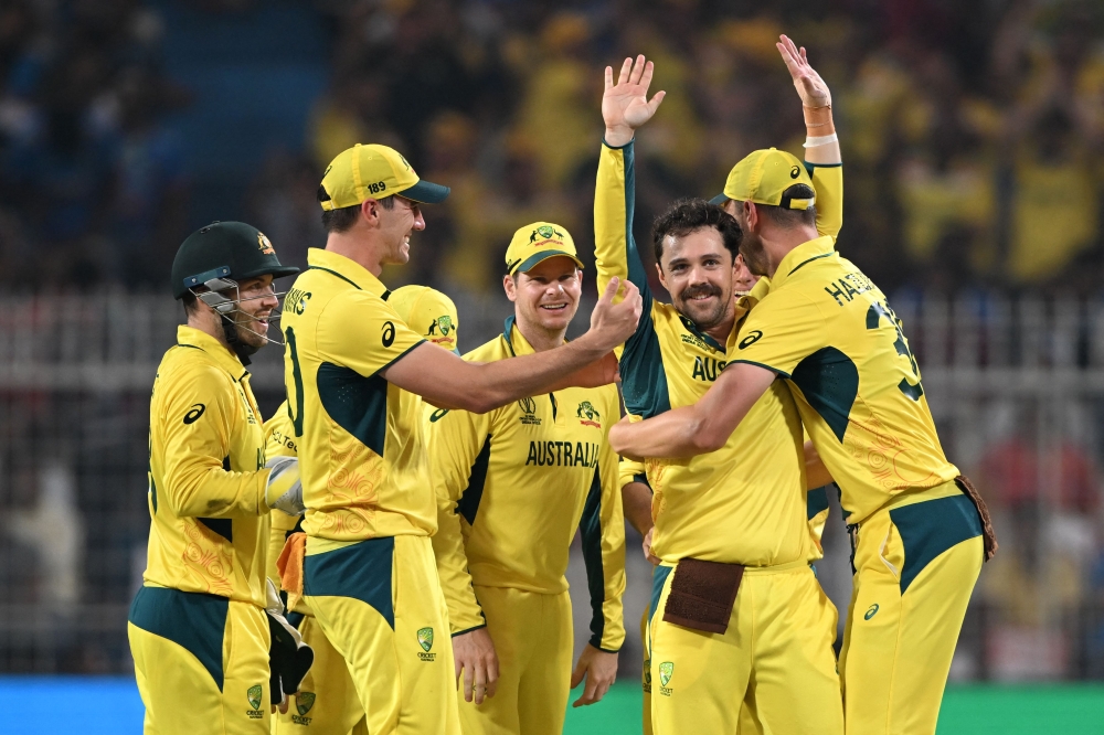 Australia's Travis Head (second right) celebrates with teammates after taking the wicket of South Africa's Heinrich Klaasen during the 2023 ICC Men's Cricket World Cup one-day international (ODI) second semi-final match between Australia and South Africa at the Eden Gardens in Kolkata on November 16, 2023. (Photo by Dibyangshu Sarkar / AFP)