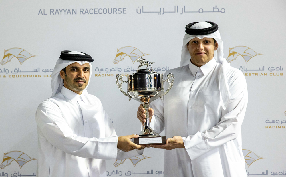 Qatar Racing and Equestrian Club’s Acting CEO Bader Mohammed Al Darwish presents the Barzan Cup winner's trophy to representative of Al Wasmiyah Farm after Gubbass was ridden to victory by Jefferson Smith during the Eighth Al Rayyan Meeting, yesterday. PICTURES: JUHAIM/QREC