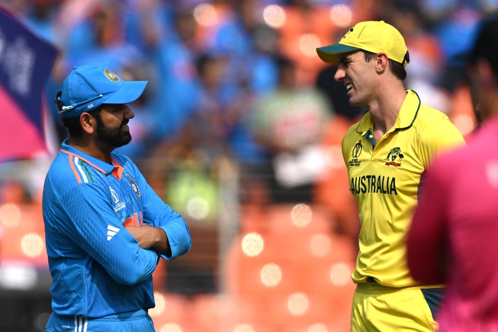 Australia's captain Pat Cummins (R) speaks with his Indian counterpart Rohit Sharma during the toss before the start of the 2023 ICC Men's Cricket World Cup one-day international (ODI) final match between India and Australia at the Narendra Modi Stadium in Ahmedabad on November 19, 2023. Photo by Punit PARANJPE / AFP