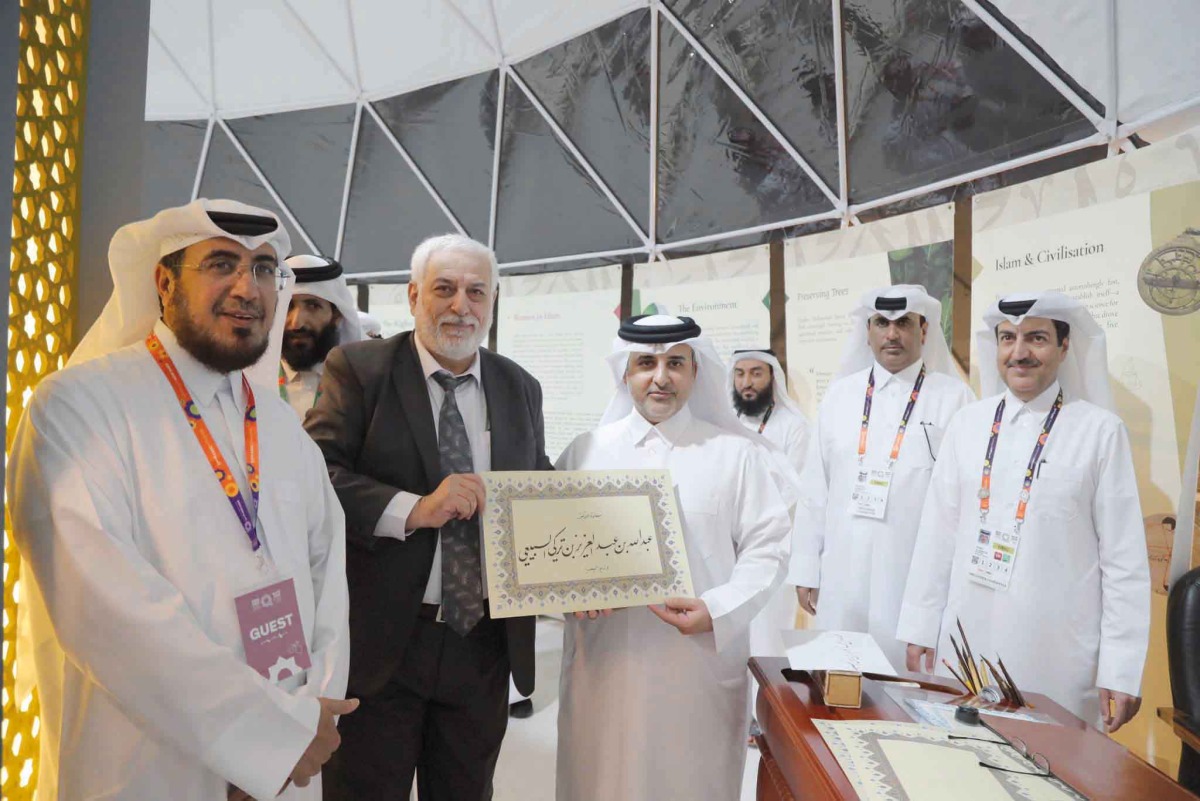 Minister of Municipality H E Dr. Abdullah bin Abdulaziz bin Turki Al Subaie is presented a plaque bearing his name by a calligrapher during the opening of the pavilion of the Ministry of Awqaf and Islamic Affairs at the Expo 2023 Doha yesterday.
