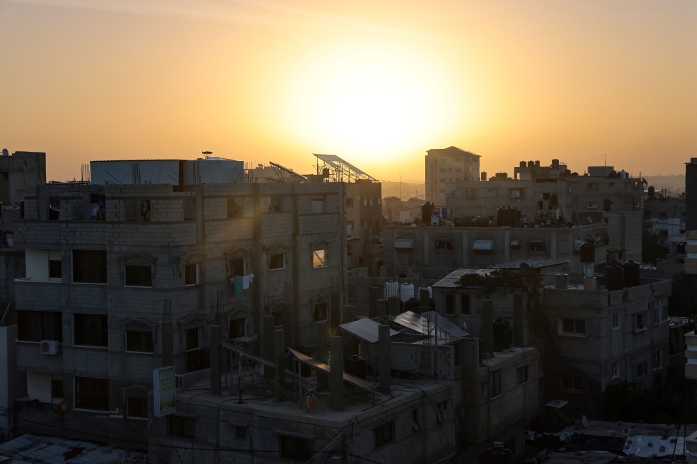 The sun rises over Rafah in the southern Gaza Strip shortly before the start of a four-day truce, on November 24, 2023. Photo by Mohammed ABED / AFP