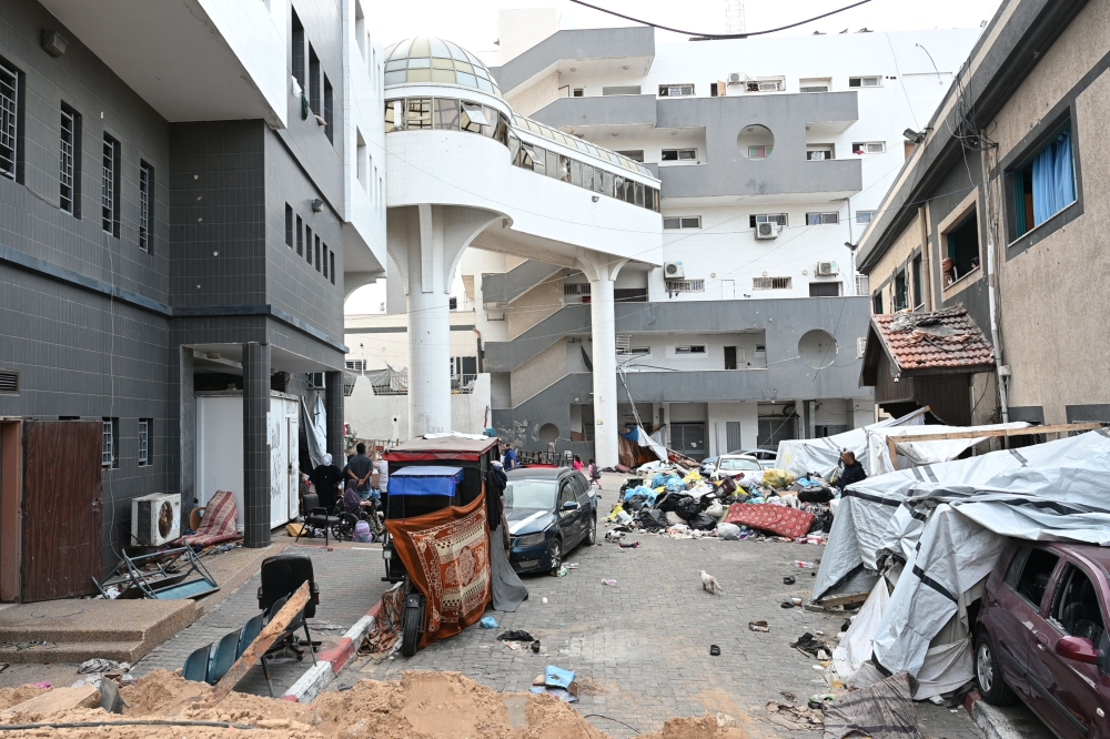 Palestinians gather outside one of the departments of the Al-Shifa hospital complex in Gaza City in the northern Gaza Strip on November 22, 2023. (Photo by Ahikam Seri / AFP)

