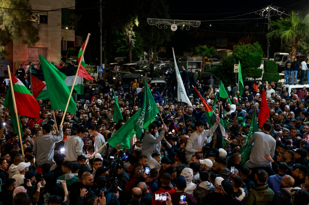 Palestinian (wearing grey jumpers) after being released from Israeli prison in Ramallah cheer among supporters in the occupied West Bank early on November 26, 2023. (Photo by Jaafar Ashtiyeh / AFP)