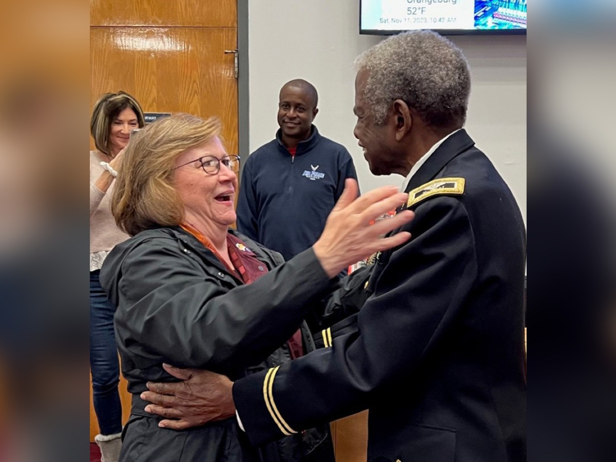 Kris Feeney and Col. Ned Felder hug at their first meeting, with his oldest son in the background. Courtesy of South Carolina State University.