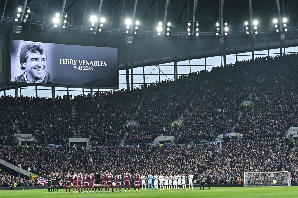A picture of former England player and coach Terry Venables is shown on the video screen as team players a members of the public pay a tribute for him following the announcement of his passing away prior to the English Premier League football match between Tottenham Hotspur and Aston Villa at Tottenham Hotspur Stadium in London, on November 26, 2023. (Photo by Ben Stansall / AFP) 