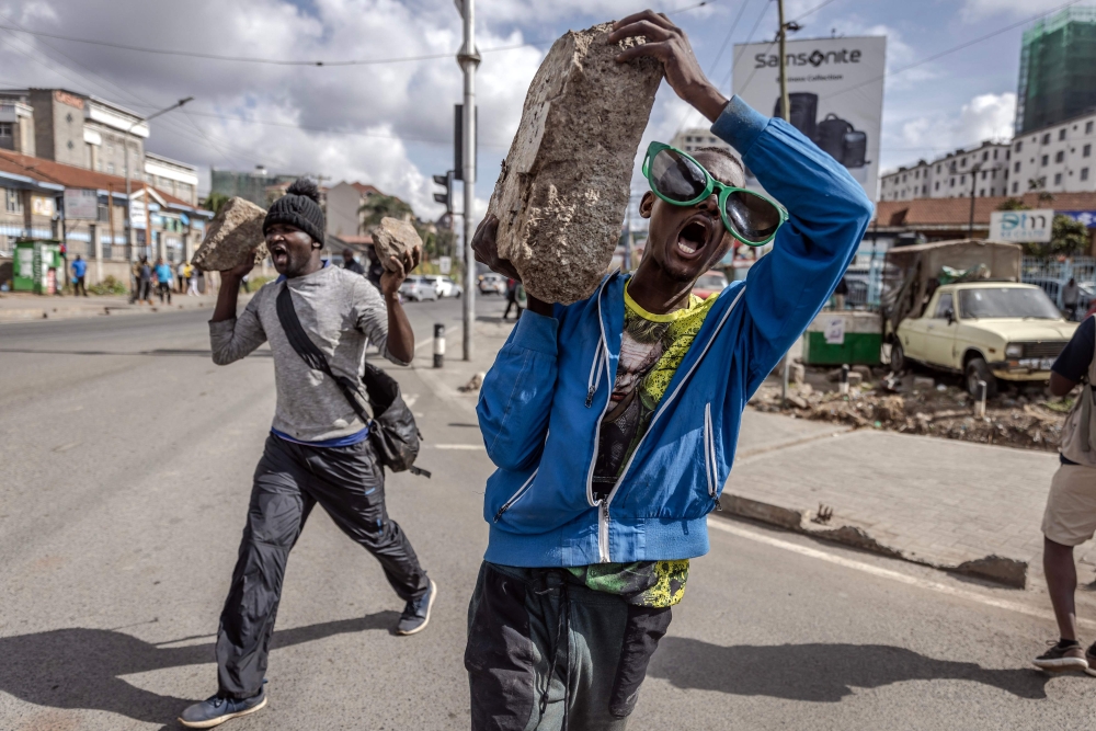File: Opposition supporters carry stones and chant slogans demanding lower taxes and a reduced cost of living in Nairobi, Kenya, on March 20, 2023. Kenyans face economic hardship following the government's recent tax measures and increased food and fuel prices. (Photo by Luis Tato / AFP)