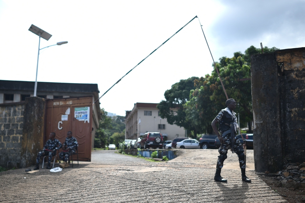 Members of the Sierra Leonean Police Forces guard the entrance to the Sierra Leone Broadcasting Corporation in Freetown on November 27, 2023. (Photo by Saidu BAH / AFP)
