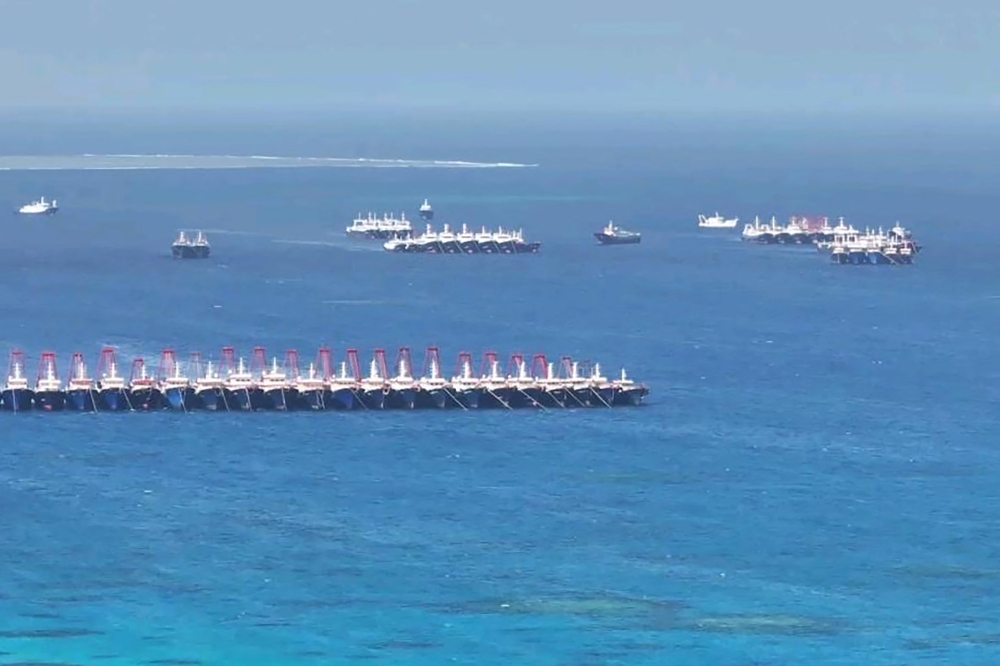 This handout photo taken on December 2, 2023, by the Philippine Coast Guard (PCG) shows an aerial view of Chinese vessels gathered by Whitsun Reef. (Photo by Handout / Philippine Coast Guard (PCG) / AFP) 
