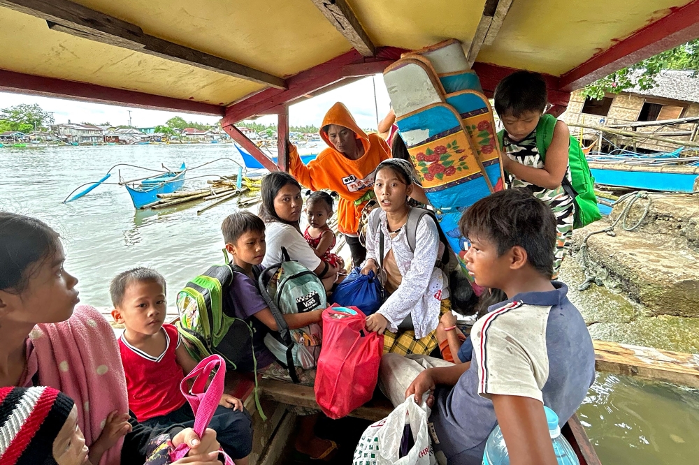 Earthquake-affected residents ride a boat as they evacuate from Hinatuan, Surigao del Sur province on December 3, 2023, following a 7.6 magnitude quake late on December 2. (Photo by AFP)