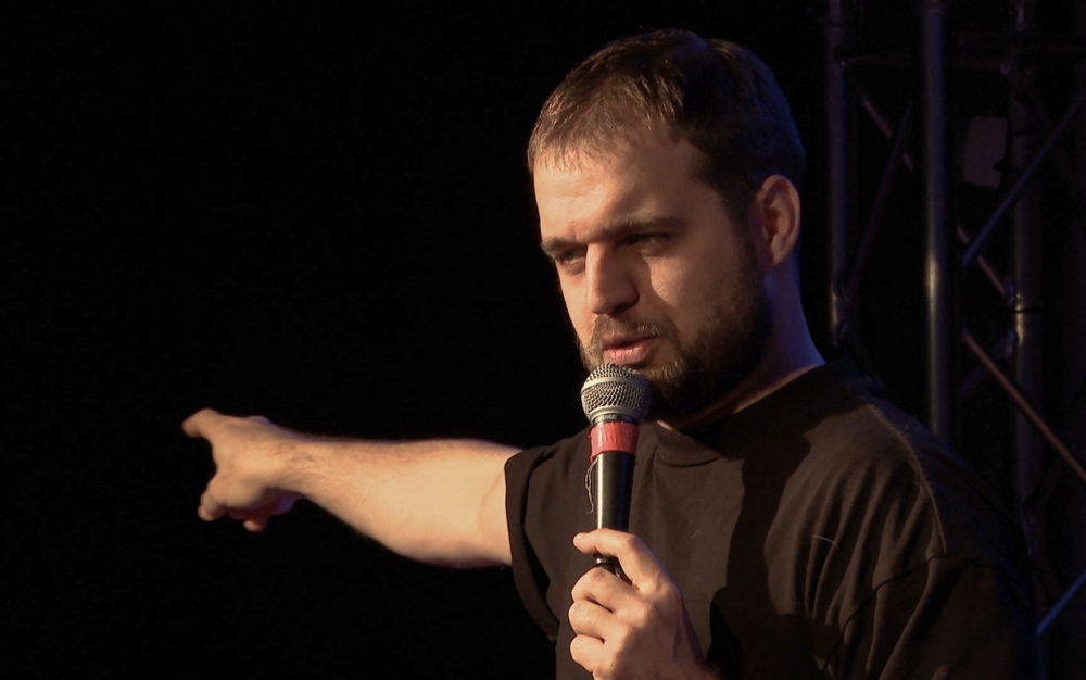 Video grab taken from an AFP footage dated November 27, 2023 shows Russian comic Dan the Stranger performing on stage in a club in Munich, southern Germany. (Photo by Pauline Curtet / AFP)