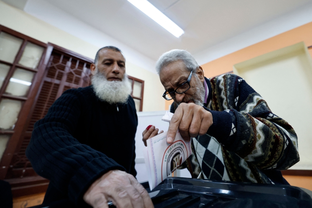 An Egyptian man casts his ballot during the presidential election, at a polling station in downtown Cairo on December 10, 2023. (Photo by Khaled Desouki / AFP)