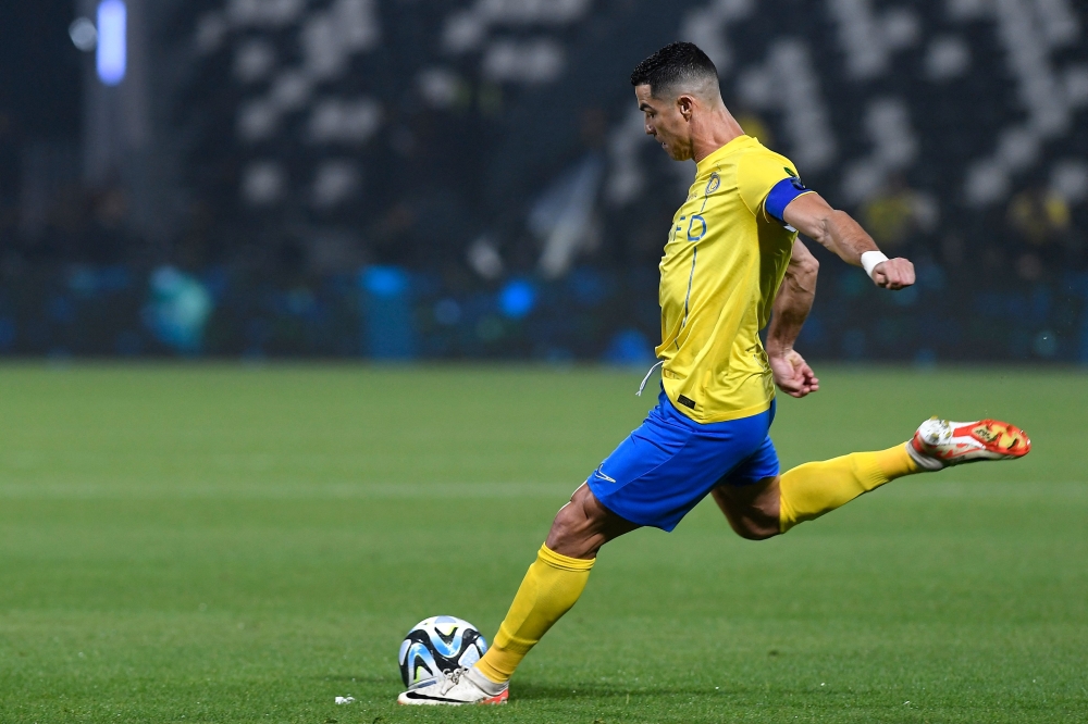 Nassr's Portuguese forward #07 Cristiano Ronaldo shoots the ball during the King Cup quarter-final football match between Al-Shabab and Al-Nassr at the Al-Shabab Club Stadium in Riyadh on December 11, 2023. (Photo by AFP)
