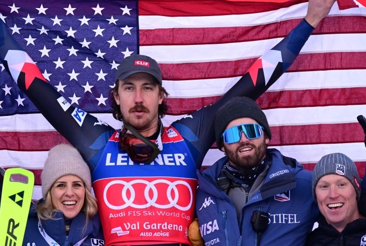 First placed US' Bryce Bennett celebrates with team members on the podium after winning the men's downhill replacing Zermatt-Cervinia's race, during the FIS Alpine Ski World Cup in Val Gardena on December 14, 2023. (Photo by Tiziana FABI / AFP)
