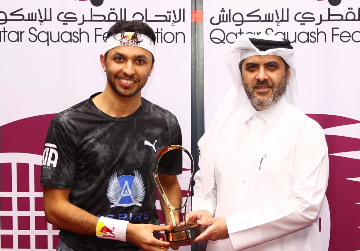 Qatar’s Abdulla Al Tamimi (left) poses with the trophy with Secretary General of the Qatar Tennis, Squash and Badminton Federation Tariq Darwish Zainal.  