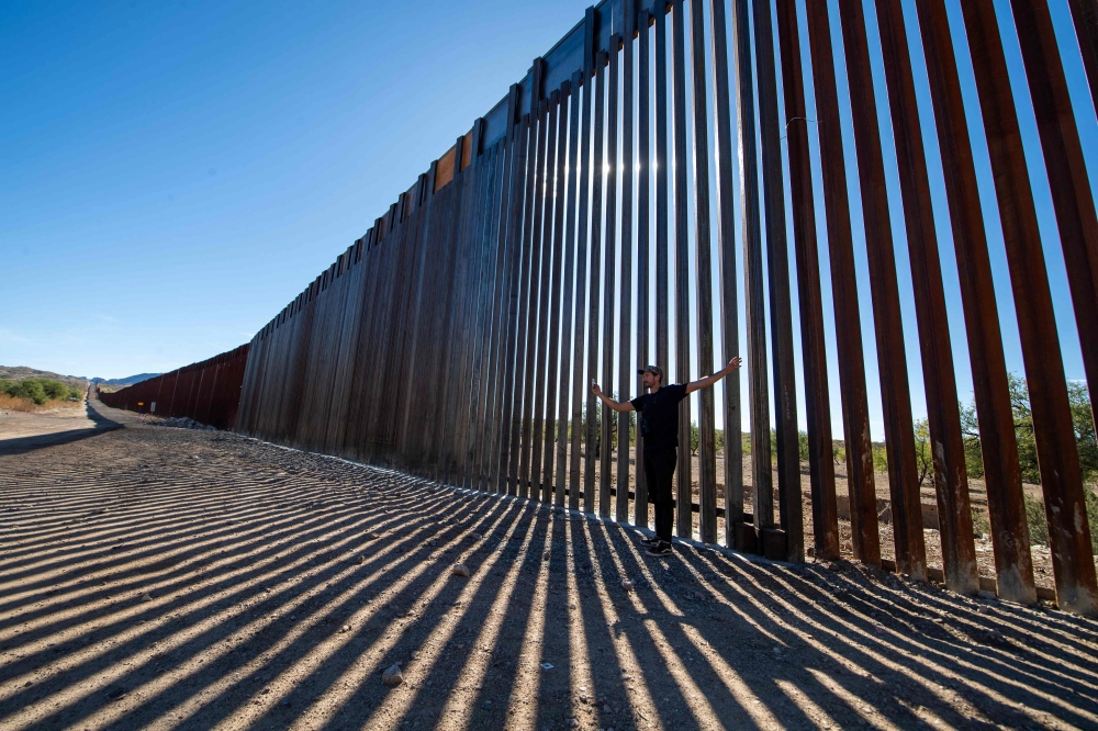 Laiken Jordahl, Southwest Conservation Advocate, makes a video in front of a section of the US-Mexico border wall in Sasabe, Arizona on December 8, 2023.  (Photo by VALERIE MACON / AFP)