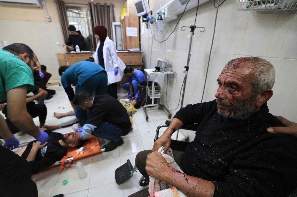 Medics treat Palestinians injured in Israeli bombardment, at Nasser hospital in Khan Yunis in the southern Gaza Strip on December 17, 2023. Photo by Mahmud HAMS / AFP