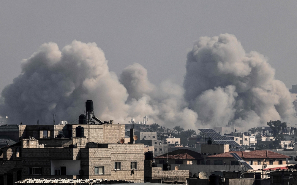 Smoke billows over Khan Yunis in the southern Gaza strip during Israeli bombardment on December 17, 2023. Photo by Mahmud HAMS / AFP