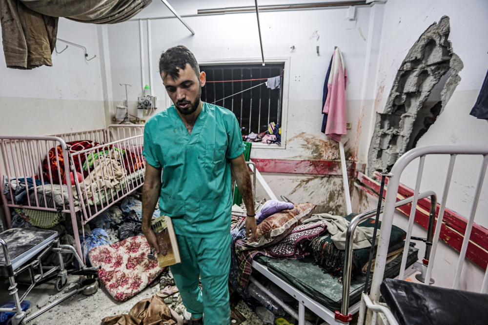 A man inspects the damage in a room following Israeli bombardment at Nasser hospital in Khan Yunis in the southern Gaza Strip on December 17, 2023. Photo by STRINGER / AFP