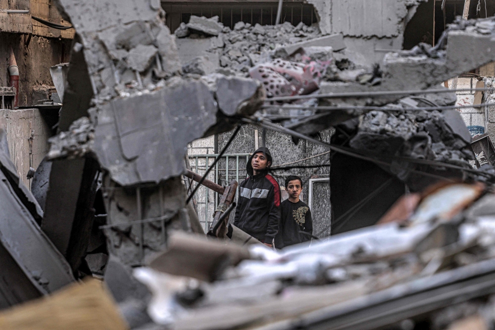 People inspect the rubble of a building destroyed by Israeli bombardment in Rafah in the southern Gaza Strip on December 24, 2023. (Photo by Said Khatib / AFP)