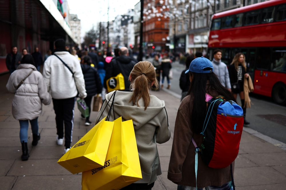 Shoppers carry their shopping bags along Oxford Street during the Boxing Day sales in London on December 26, 2023. (Photo by HENRY NICHOLLS / AFP)
