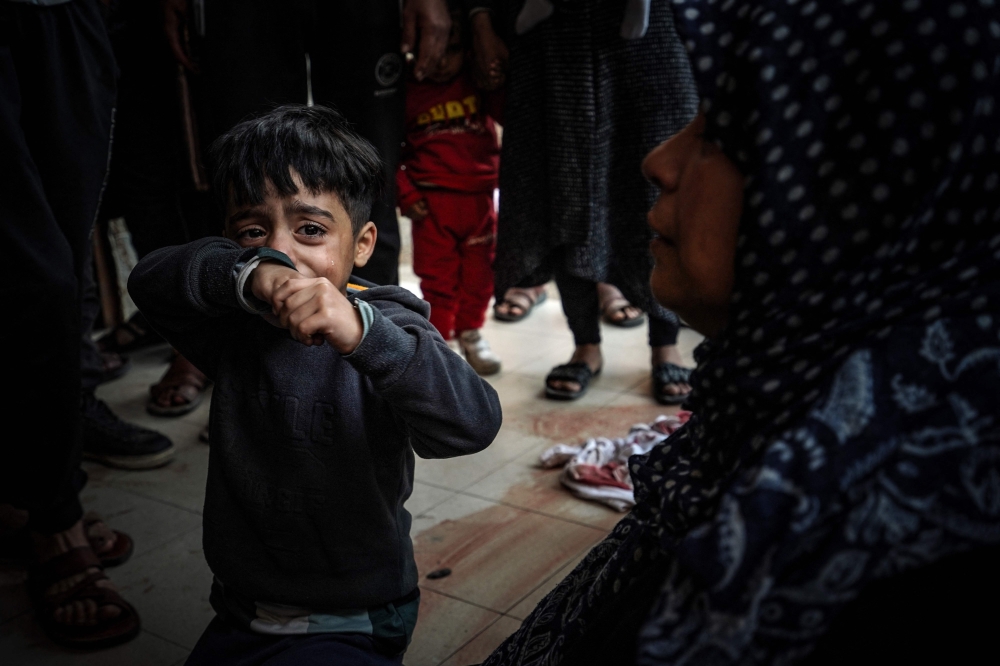 A child cries as people mourn loved ones killed during Israeli bombardment at Nasser Hospital in Khan Yunis on the southern Gaza Strip on December 27, 2023. Photo by AFP