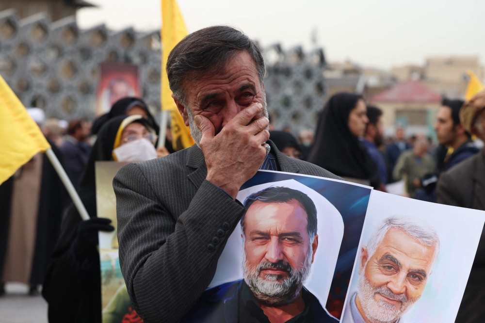 An Iranian mourns during the funeral of Razi Moussavi on December 28, 2023. (Photo by Atta Kenare / AFP)