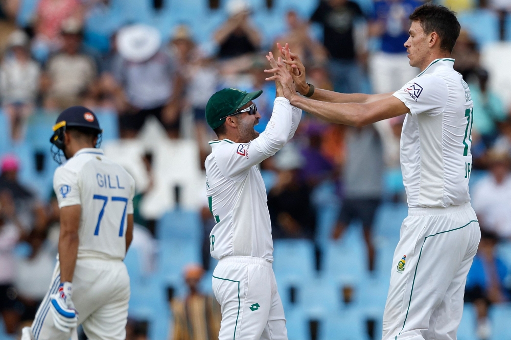 South Africa's Marco Jansen (R) celebrates with South Africa's Dean Elgar (C) after the dismissal of India's Shreyas Iyer (L) during the third day of the first cricket Test match between South Africa and India at SuperSport Park in Centurion on December 28, 2023. (Photo by PHILL MAGAKOE / AFP)
