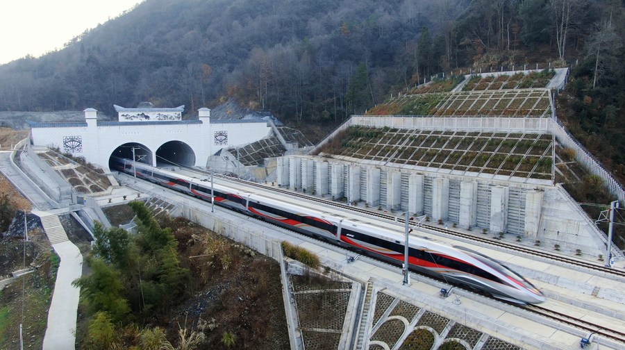 This aerial photo shows a train departing from Yixian East Railway Station in Huangshan City, east China's Anhui Province, Dec. 27, 2023. (Photo by Lyu Jinyi/Xinhua)