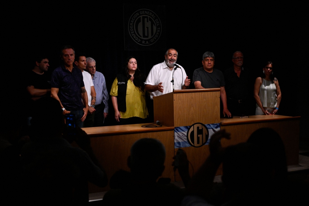 Hector Daer (C), the general secretary of the General Confederation of Labor (CGT), speaks accompanied by other union leaders during a press conference at CGT headquarters in Buenos Aires on December 28, 2023. (Photo by LUIS ROBAYO / AFP)
