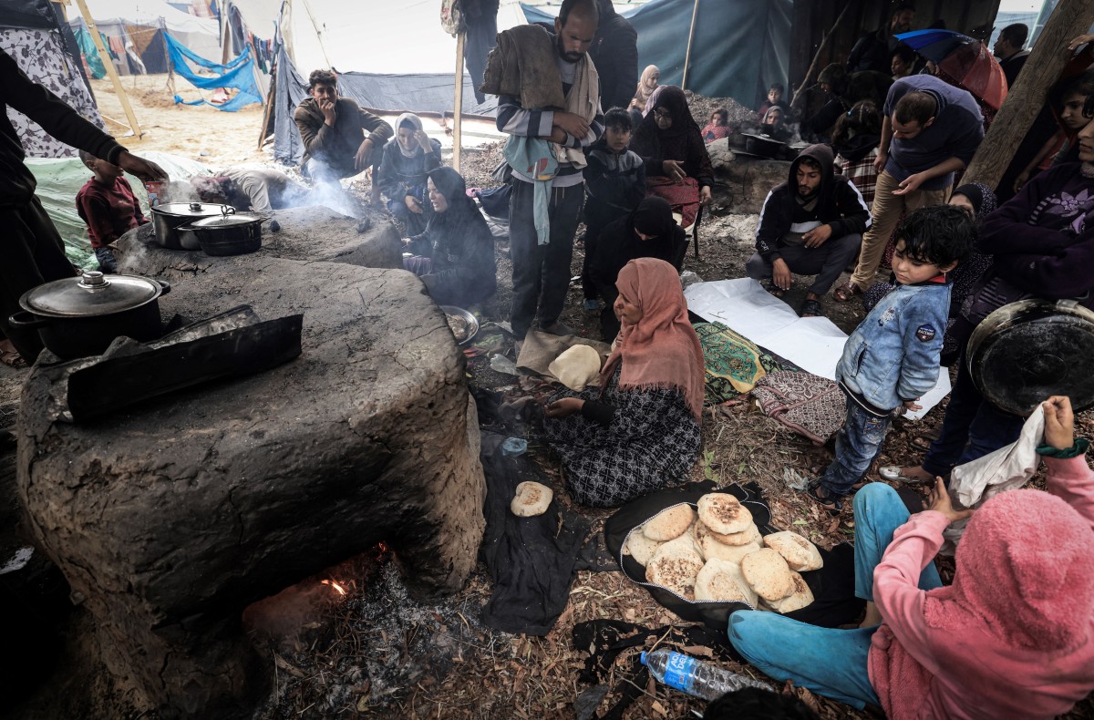 Palestinian women make break in ovens at a makeshift camp housing displaced Palestinians, in Rafah in the southern Gaza Strip on January 2, 2024. Photo by AFP
