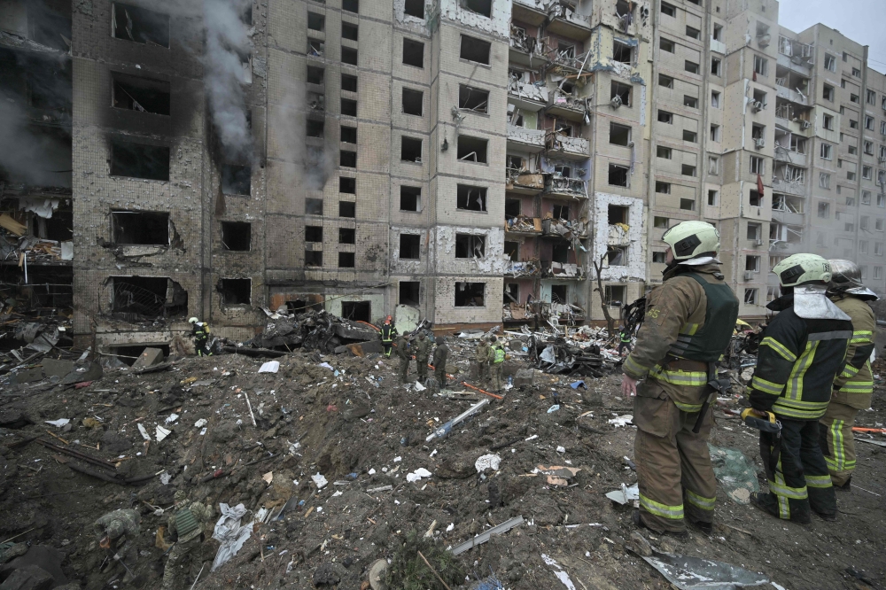 Firefighters work in a multi-storey residential building destroyed by a missile attack in central Kyiv, on January 2, 2024. (Photo by Genya Savilov / AFP)