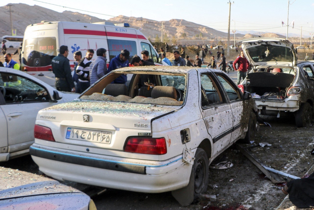 This photograph taken on January 3, 2024 shows destroyed cars and emergency services near the site where two explosions in quick succession struck a crowd marking the anniversary of the 2020 killing of Guards general Qasem Soleimani, near the Saheb al-Zaman Mosque in the southern Iranian city of Kerman. (Photo by TASNIM NEWS / AFP)
