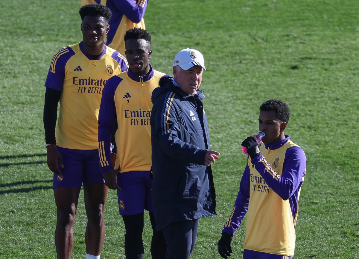 (From L) Real Madrid's French defender #18 Aurelien Tchouameni, Real Madrid's Brazilian forward #07 Vinicius Junior, Real Madrid's Italian coach Carlo Ancelotti and Real Madrid's Brazilian forward #11 Rodrygo attend a training session at the Ciudad Real Madrid training ground in Valdebebas, Madrid, on December 30, 2023. (Photo by Pierre-Philippe MARCOU / AFP)