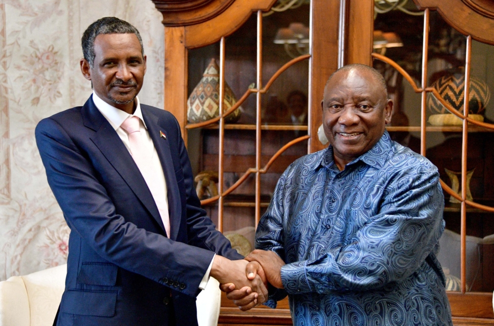 This handout photograph taken and distributed by South Africa's Government Communication And Information System (GCIS) on January 4, 2024 shows the leader of Sudan's paramilitary Rapid Support Forces (RSF) Mohamed Daglo (L) on a visit to South African President Cyril Ramaphosa (R) at his official residence in Pretoria. (Photo by GCIS / AFP)