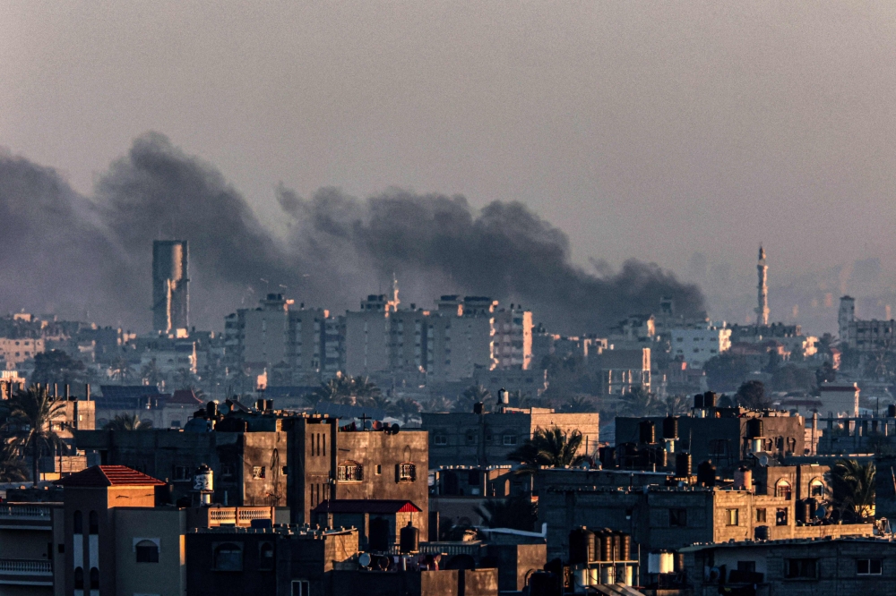 A picture taken from Rafah on January 7, 2024, shows smoke billowing over Khan Yunis in the southern Gaza Strip. (Photo by AFP)