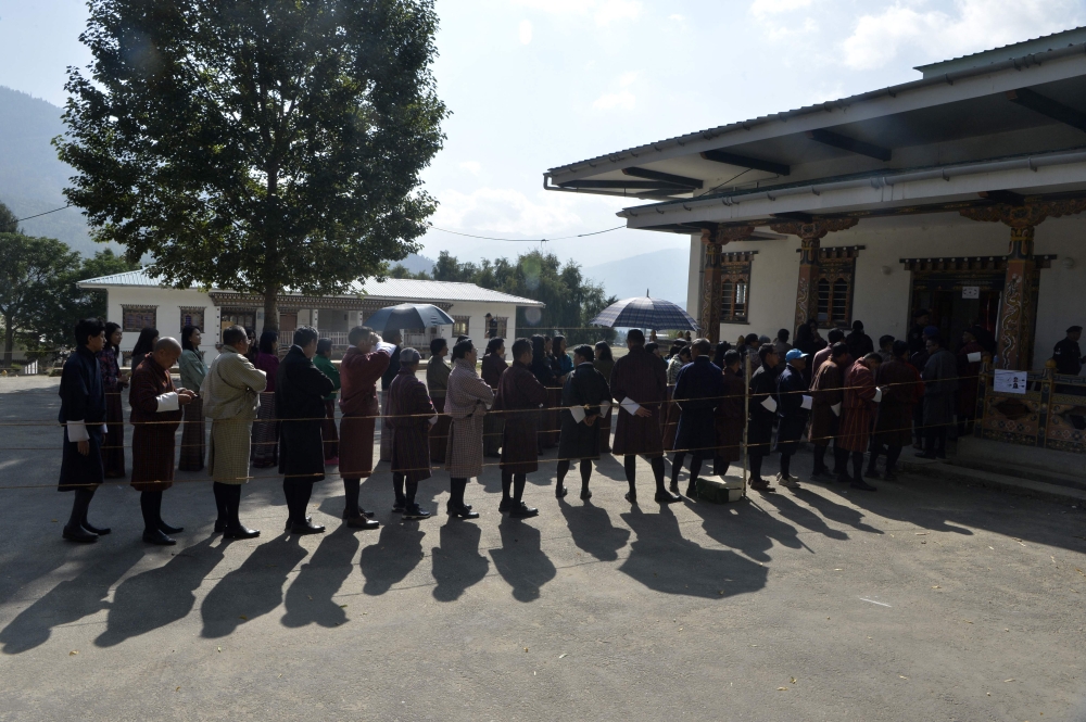 Bhutanese people line up to vote at a polling station in Thimpu on October 18, 2018. Photo by DIPTENDU DUTTA / AFP