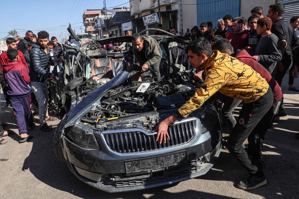 People check the car in which two journalists,Mustafa Thuria, a video stringer for AFP news agency, and Hamza Wael Dahdouh, a journalist with Al Jazeera television network, were killed in a reported Israeli strike in Rafah in the Gaza Strip on January 7, 2024. Photo by AFP