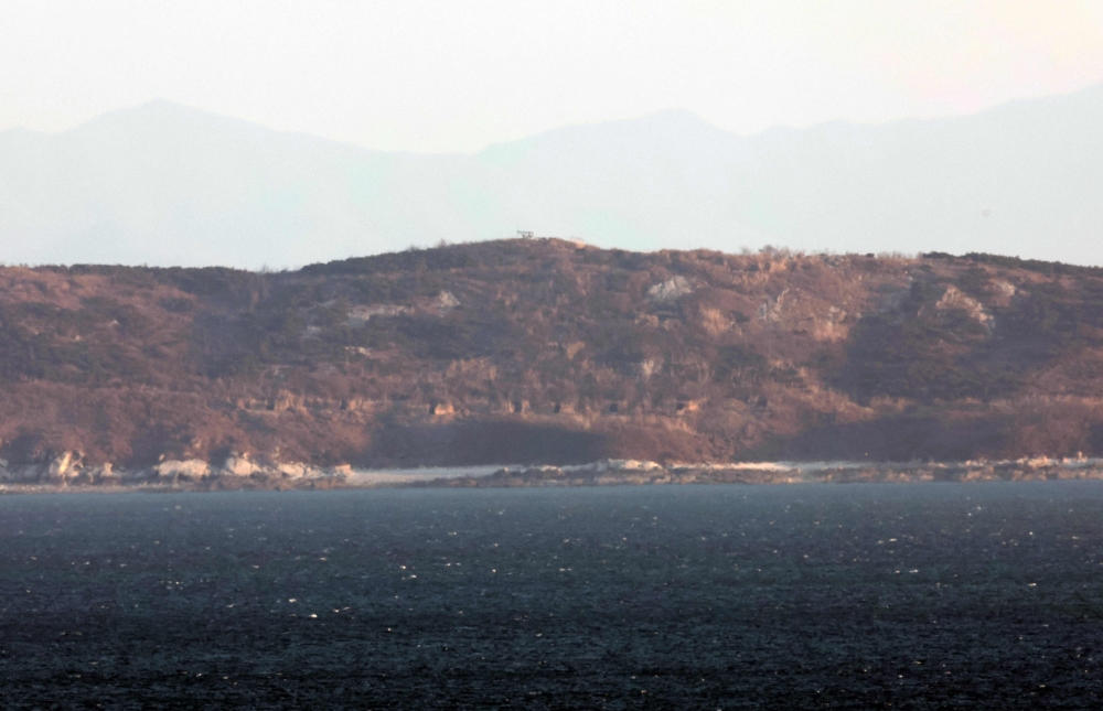 A general view shows the North Korean coastline with artillery bunkers as seen from a viewpoint on Yeonpyeong island on January 7, 2024. (Photo by Stringer / Yonhap / AFP)