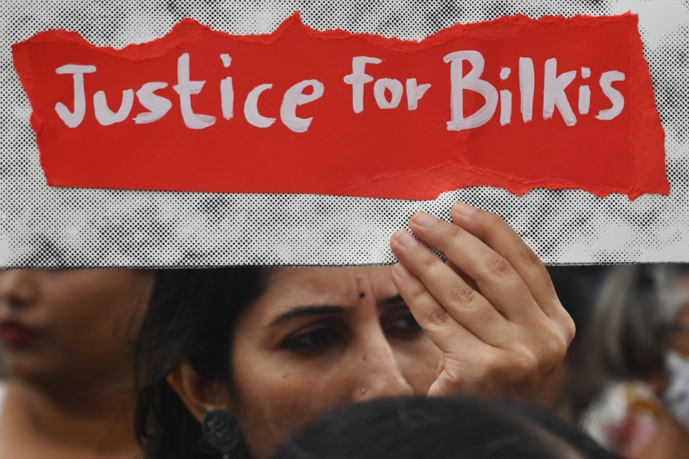 (Files) A woman holds a placard during a protest against the release of 11 men convicted in Bilkis Bano case in Mumbai on August 23, 2022. (Photo by Indranil Mukherjee / AFP)