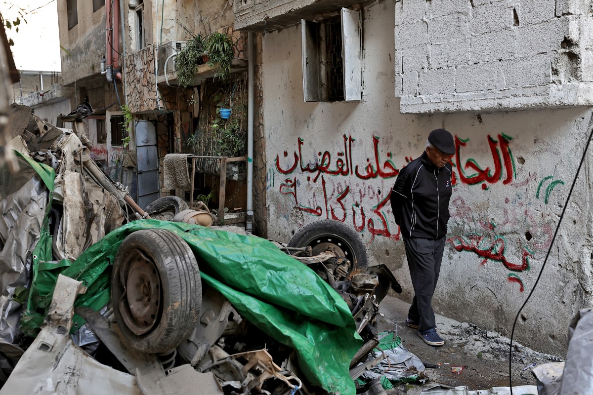 A man walks next to a destroyed car following an overnight Israeli raid on the Tulkarm refugee camp in the occupied West Bank, on January 9, 2024. Photo by Zain JAAFAR / AFP