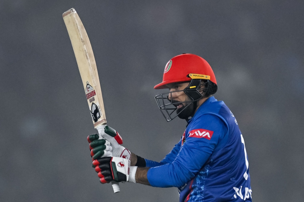 Afghanistan's Mohammad Nabi watches the ball after playing a shot during the first Twenty20 international cricket match between India and Afghanistan at the Punjab Cricket Association Stadium in Mohali on January 11, 2024. (Photo by Arun SANKAR / AFP)