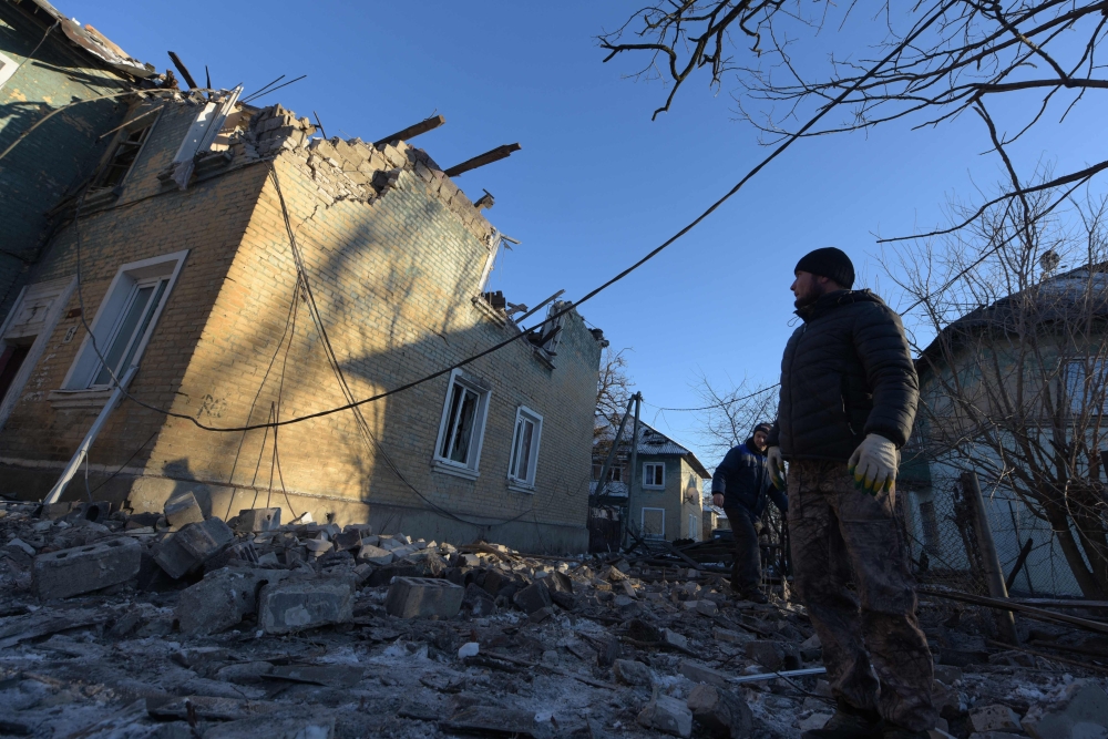 A man looks at a damaged two-storey housing block hit by recent shelling in Makiivka (Makeyevka), on January 12, 2024. (Photo by Stringer / AFP)
 