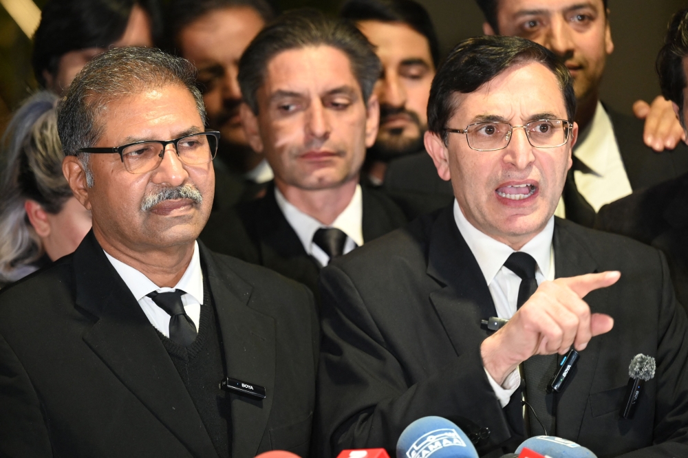 Pakistan Tehreek-e-Insaf (PTI) party's chief Gohar Khan (R) and legal team members speak to media outside the Supreme Court building after court verdict in Islamabad on January 13, 2024. (Photo by Aamir Qureshi / AFP)