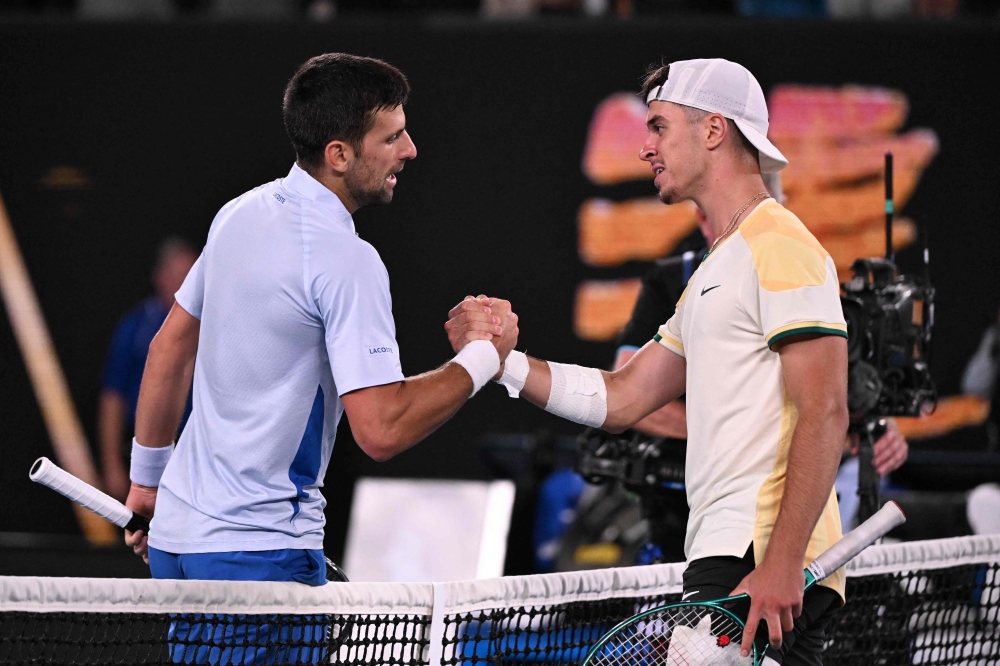 Serbia's Novak Djokovic (L) greets Croatia's Dino Prizmic after beating him in their men's singles match on day one of the Australian Open tennis tournament in Melbourne on January 14, 2024. (Photo by WILLIAM WEST / AFP)