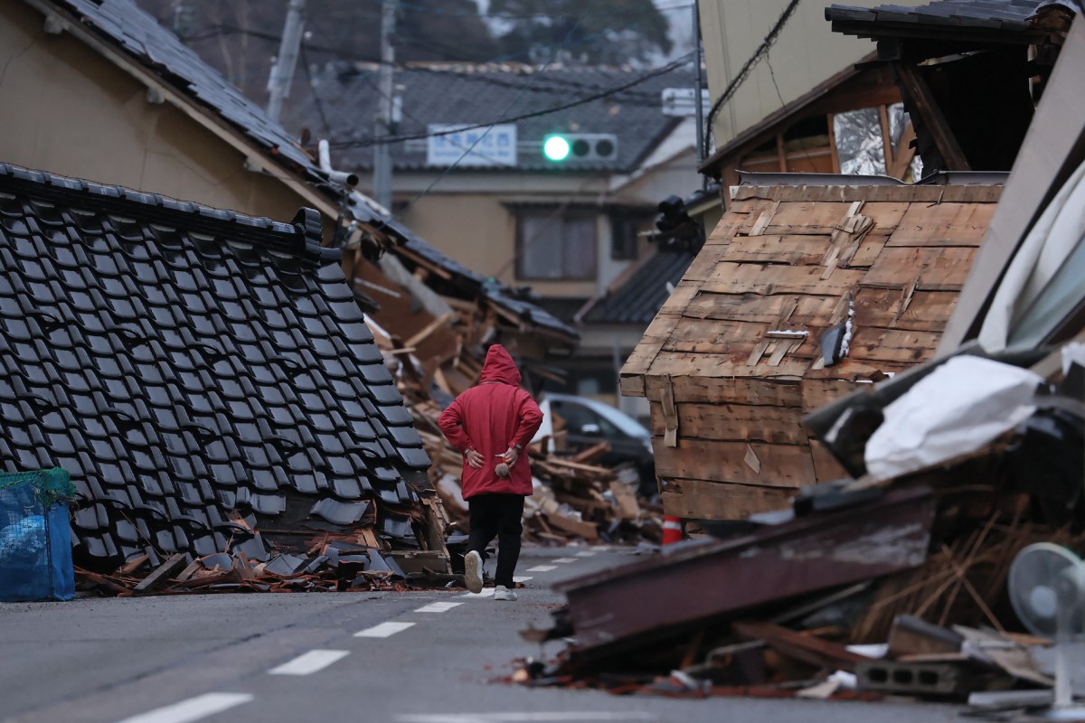 This photo taken on January 15, 2024 shows collapsed houses blocking a road in the disaster-hit city of Wajima, Ishikawa prefecture, two weeks after a major 7.5 magnitude earthquake struck the Noto region in Ishikawa prefecture on New Year's Day. (Photo by JIJI PRESS / AFP) / JAPAN OUT
