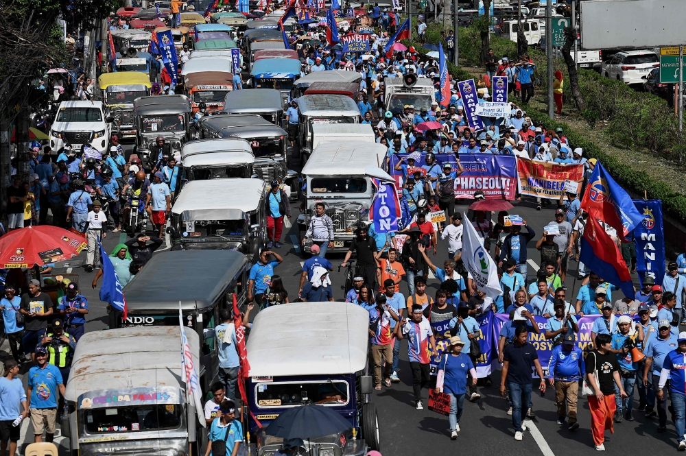 Jeepney drivers and operators march during a protest against the jeepney modernisation program in Manila on January 16, 2024. Photo by JAM STA ROSA / AFP
