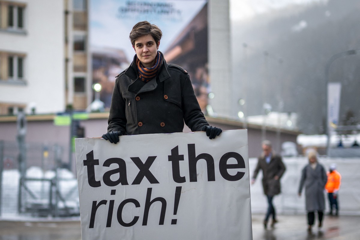 Austrian Marlene Engelhorn, who inherited from her family who owns the Germany's chemical giant BASF, poses with a placard reading 