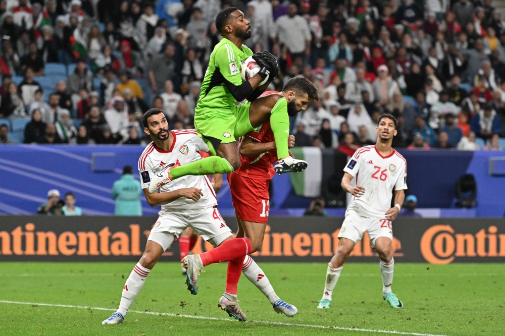 UAE's goalkeeper #17 Khalid Eisa jumps to save the ball during the Qatar 2023 AFC Asian Cup Group C football match between Palestine and United Arab Emirates at the Al Janoub Stadium on January 18, 2024. (Photo by Hector Retamal / AFP)