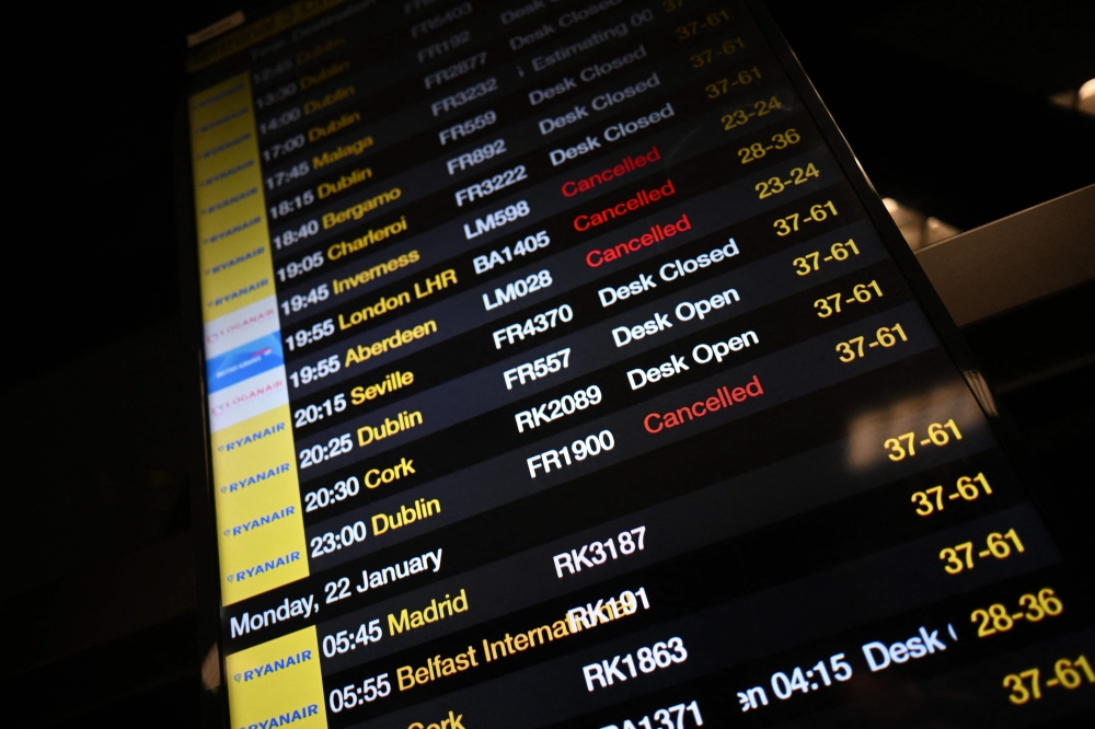 The departure board at Manchester Airport shows many flights cancelled or delayed due to high winds caused by Storm Isha on January 21, 2024. (Photo by Paul Ellis / AFP)